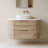 Valco 750mm curved wall hung plywood vanity in Nature Oak timber look, styled with a white fluted basin, brushed gold wall tapware, and an arch mirror in a Japandi bathroom.