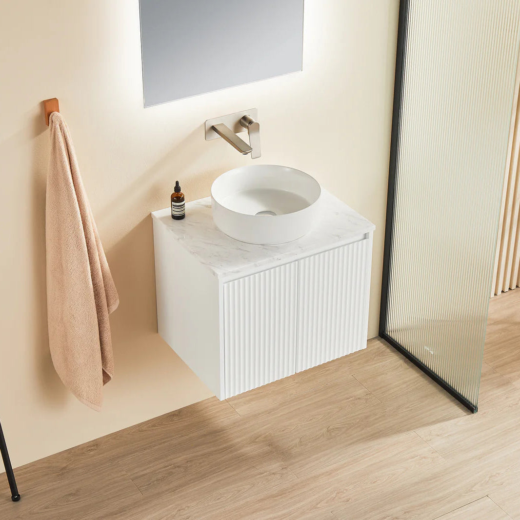 Modern bathroom with white vanity, sink, and mirror in a neutral color scheme.