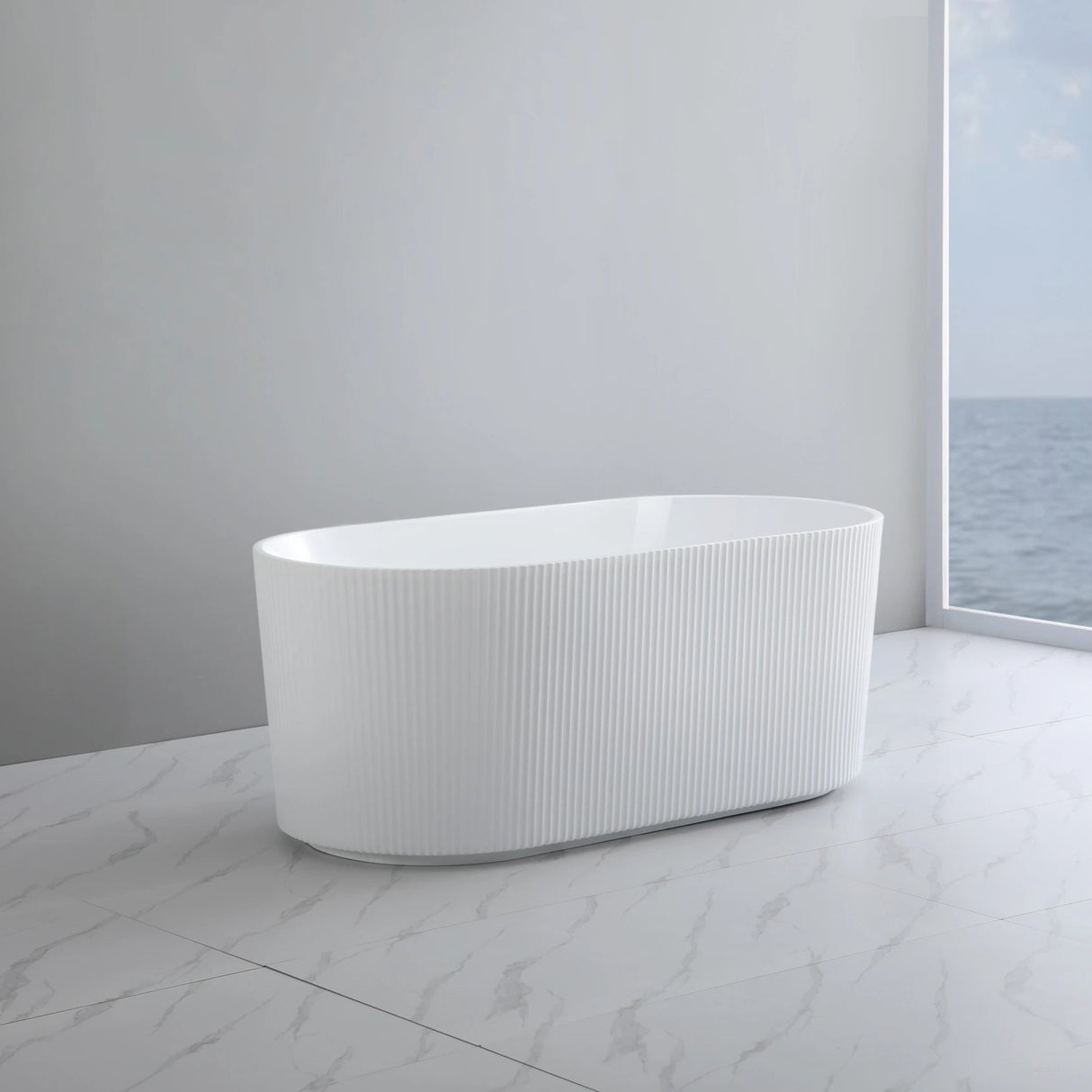 White freestanding bathtub in a modern bathroom with a large window view of water.