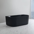 Black freestanding bathtub in a modern bathroom with a window view.