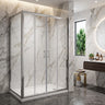 Chrome semi frameless corner shower screen with centre opening sliding doors and return panel in a marble bathroom