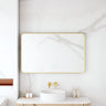 Maia 1200x750mm rectangular motion sensor LED mirror with brushed gold frame in a bathroom above a round basin