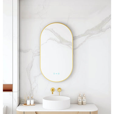 Maia 500x900mm oval motion sensor LED mirror with brushed gold frame in a bathroom above a round basin