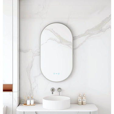 Maia 500x900mm oval motion sensor LED mirror with gun metal frame in a bathroom above a round basin