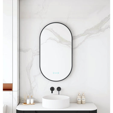 Maia 500x900mm oval motion sensor LED mirror with matte black frame in a bathroom above a round basin