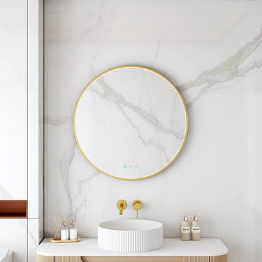 Maia 600mm round motion sensor LED mirror with brushed gold frame in a bathroom above a round basin