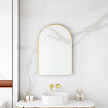 Maia 600x900mm arch motion sensor LED mirror with brushed gold frame in a bathroom above a round basin