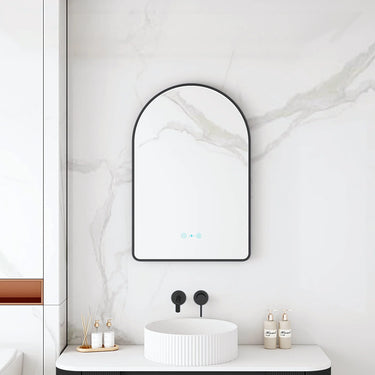 Maia 600x900mm arch motion sensor LED mirror with matte black frame in a bathroom above a round basin