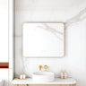 Maia 900x750mm rectangular motion sensor LED mirror with brushed gold frame in a bathroom above a round basin