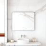 Maia 900x750mm rectangular motion sensor LED mirror with brushed nickel frame in a bathroom above a round basin