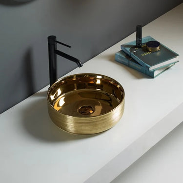 Ollia 345mm gold round above counter basin with brushed gold exterior on a white bathroom bench