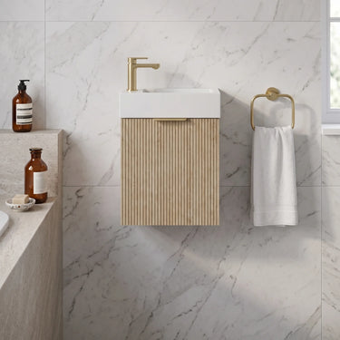 Scandinavia 450mm Classic Oak Fluted Wall Hung Vanity with poly marble basin top and brushed gold handle in a marble powder room - RJ Bathroom