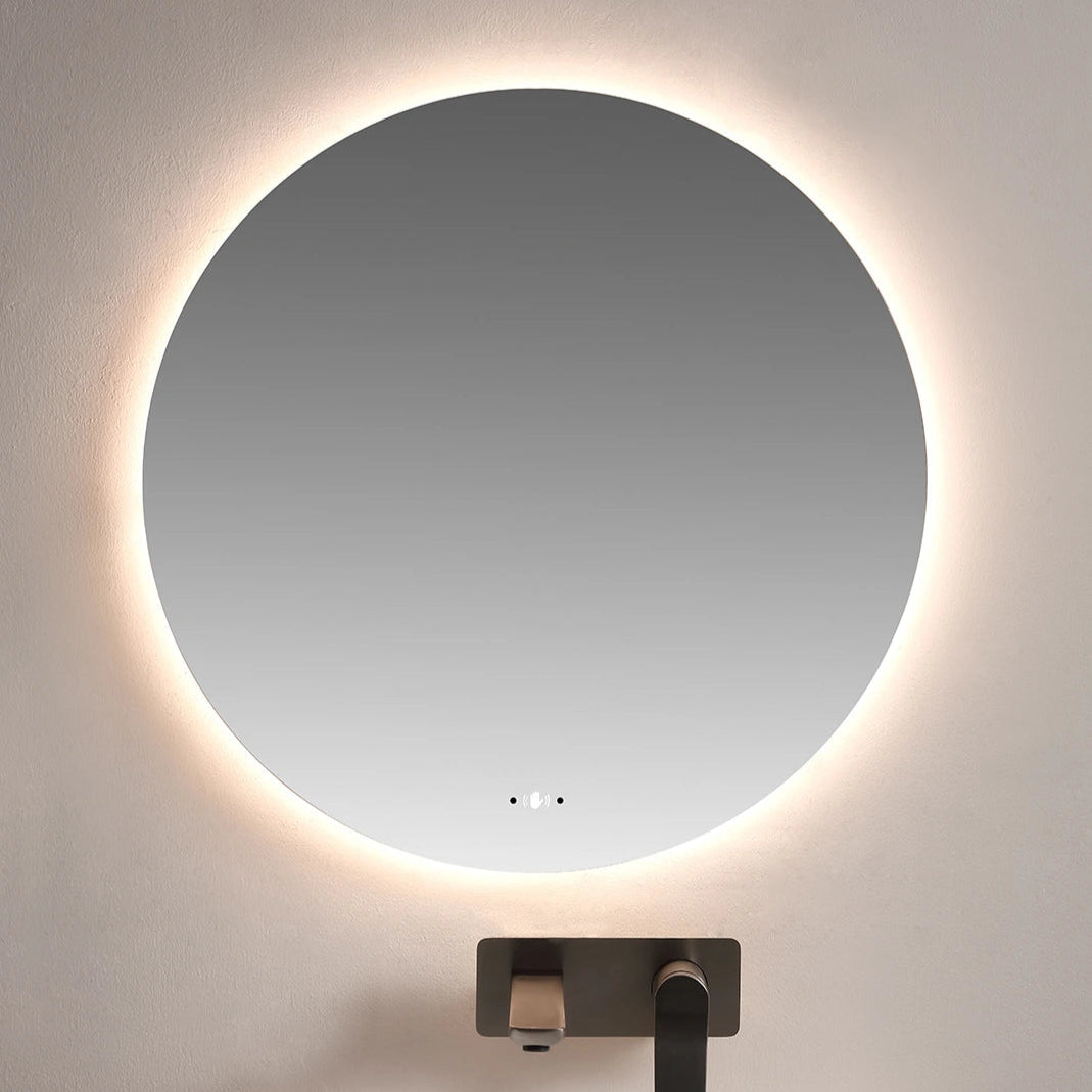 Round illuminated mirror above a sink in a bathroom setting
