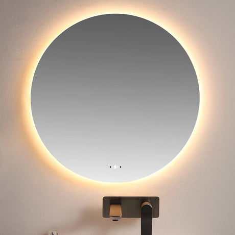 Round illuminated mirror above a sink with a modern faucet.