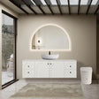 Modern bathroom with white vanity, round mirror, and freestanding bathtub.