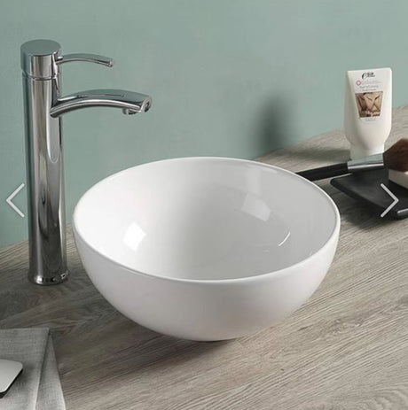White ceramic sink with chrome faucet on a wooden countertop