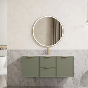 Bathroom vanity with round mirror and green cabinets against a marble wall.