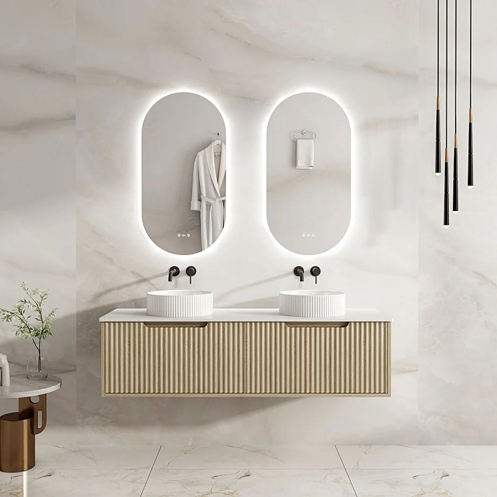 Bathroom vanity with two sinks and illuminated mirrors in a modern setting.
