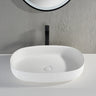 Ellips 600mm solid surface stone above counter basin in matte white with black tall basin mixer