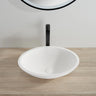 Kirra 500mm solid surface stone oval above counter basin in matte white on a timber vanity