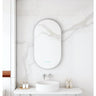 Maia 500x900mm oval motion sensor LED mirror with brushed nickel frame in a bathroom above a round basin