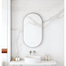Maia 500x900mm oval motion sensor LED mirror with gun metal frame in a bathroom above a round basin