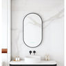 Maia 500x900mm oval motion sensor LED mirror with matte black frame in a bathroom above a round basin