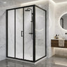 Matte black L-shaped corner sliding shower screen with 3 door slider and return panel on a shower base