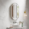 Venus 500x900mm oval front-lit motion sensor LED mirror with brushed nickel frame in a bathroom above a round basin